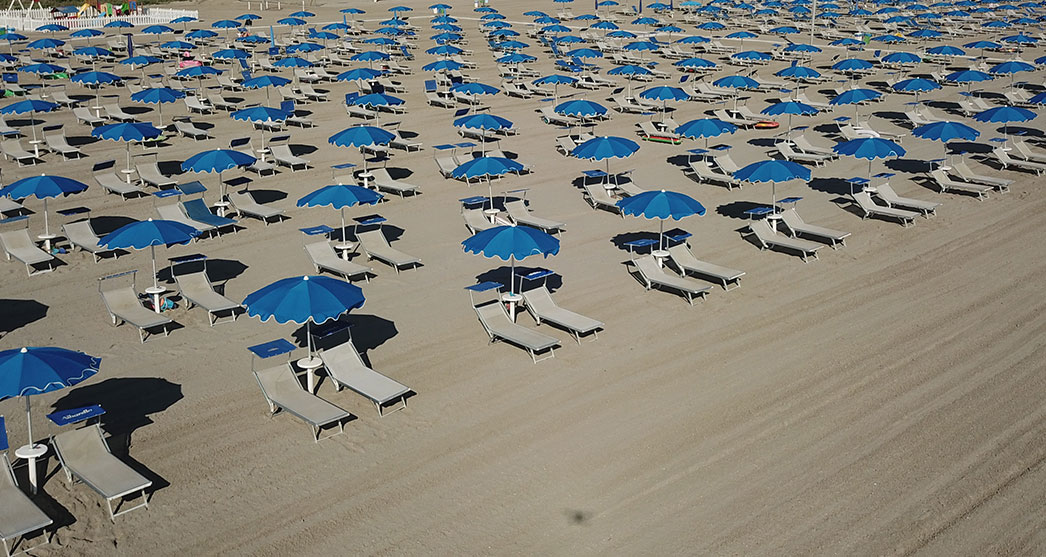 ombrelloni blu e lettini sulla spiaggia ad Albarella