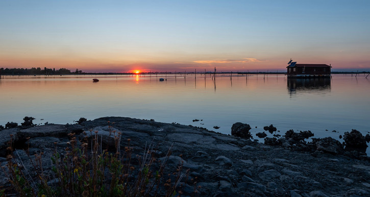 una casetta in mezzo al mare al tramonto ad Albarella
