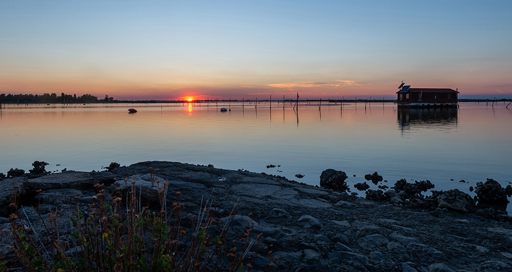 una casetta in mezzo al mare al tramonto ad Albarella