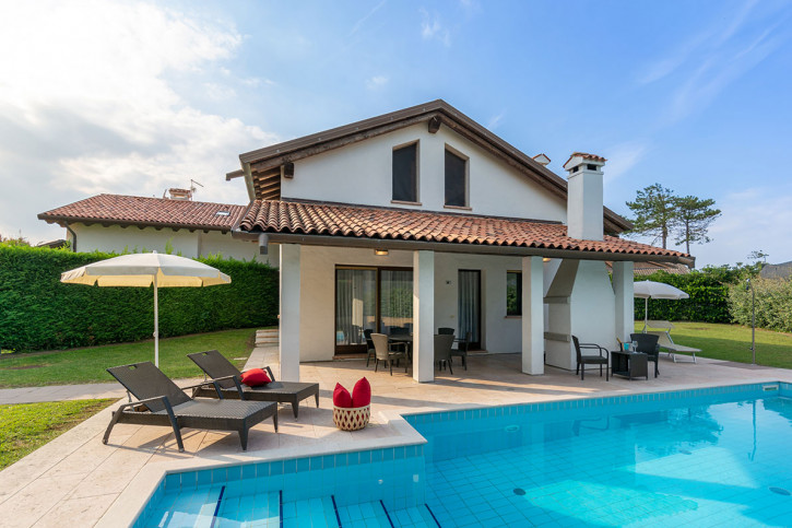 villa pentalocale con ombrellone e lettini a bordo piscina