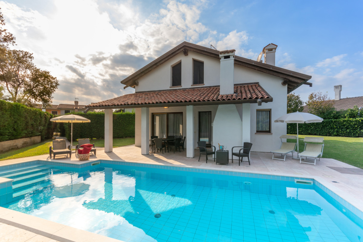 Villa con piscina ed ombrelloni da giardino ad Albarella