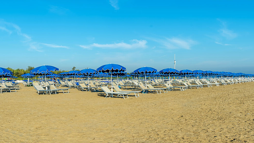 lettini crema e ombrelloni blu da spiaggia ad Albarella
